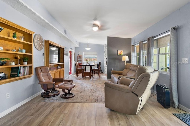 living area with visible vents, baseboards, and wood finished floors