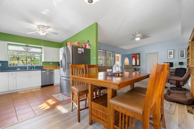 dining space featuring vaulted ceiling, light wood finished floors, and ceiling fan