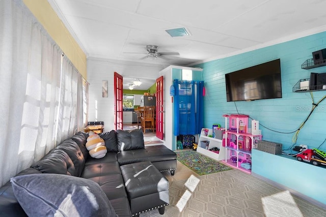 living area featuring visible vents, a ceiling fan, and crown molding