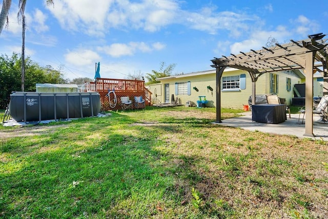 view of yard with a swimming pool, a patio area, a pergola, and a wooden deck