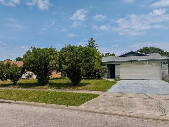 view of front facade with driveway, a front yard, and an attached garage