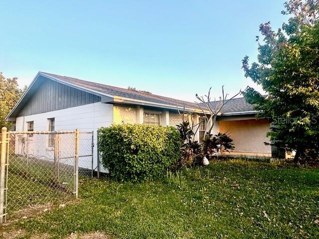 view of side of home with a yard and fence