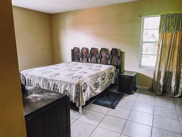 bedroom with light tile patterned floors and a textured ceiling