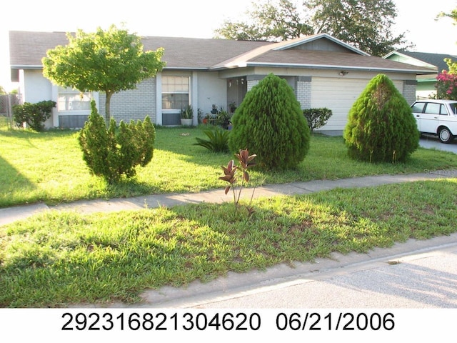 ranch-style home featuring a front lawn, an attached garage, and brick siding