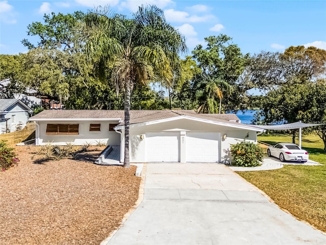 view of front of property featuring a front yard, an attached garage, driveway, and stucco siding