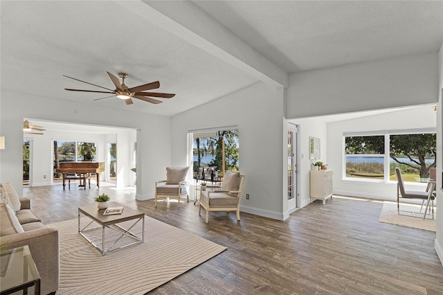 living room with lofted ceiling with beams, baseboards, wood finished floors, and ceiling fan