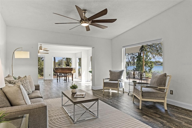 living room with a ceiling fan, baseboards, and wood-type flooring