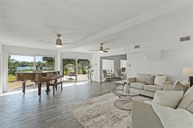 living area with ceiling fan, visible vents, a textured ceiling, and wood finished floors