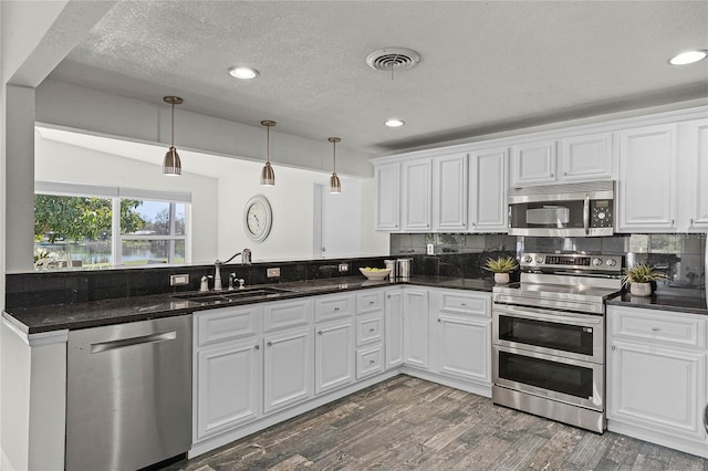 kitchen with a sink, visible vents, backsplash, and stainless steel appliances