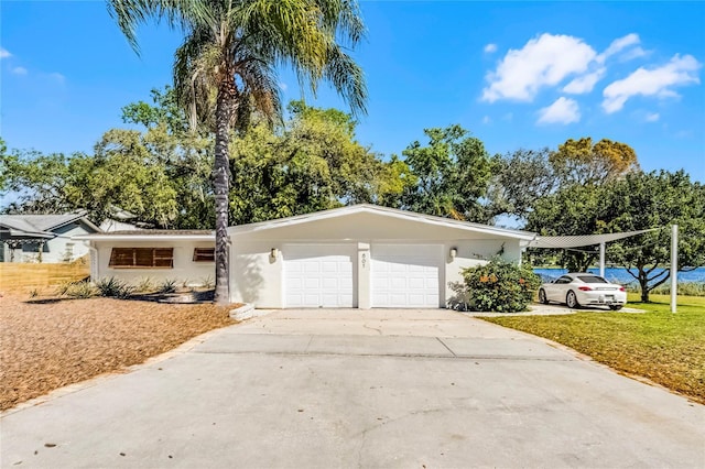 ranch-style house featuring stucco siding, a front yard, an attached garage, and driveway