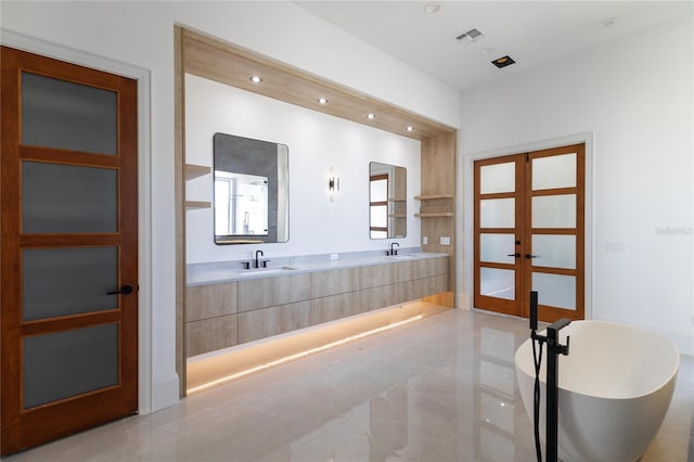 full bath featuring visible vents, recessed lighting, a freestanding bath, a sink, and french doors