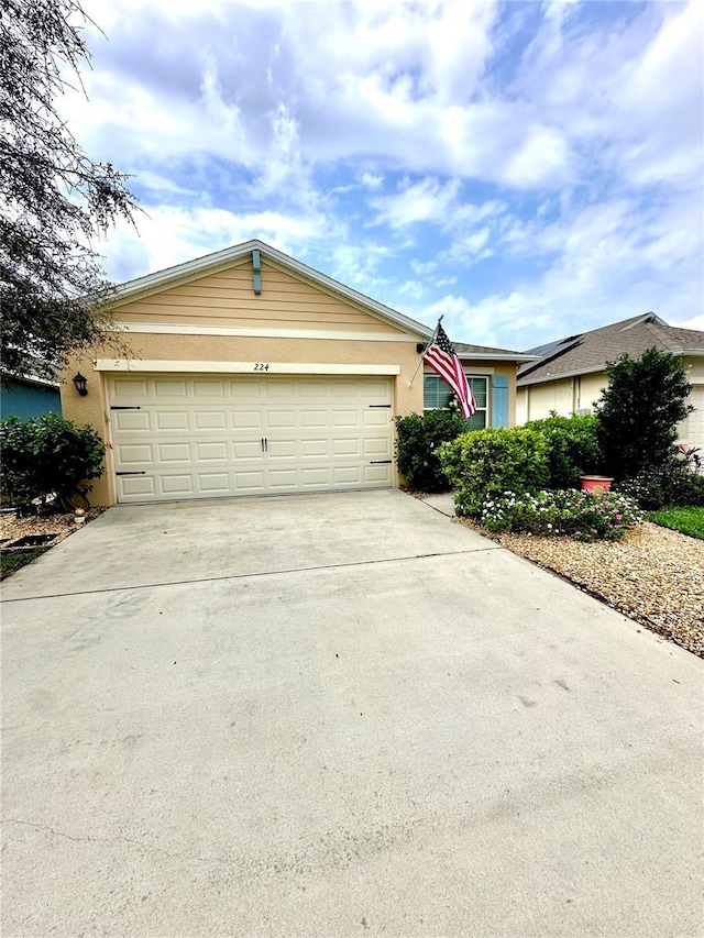 single story home featuring a garage, driveway, and stucco siding