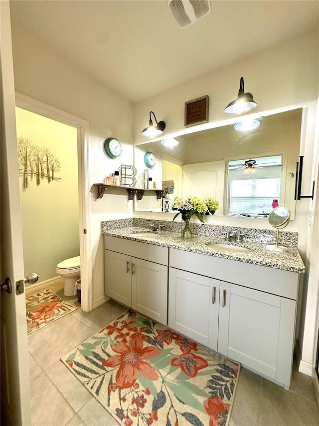 bathroom with double vanity, toilet, visible vents, and a sink