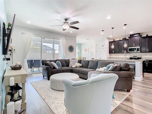 living room with light wood finished floors, recessed lighting, and ceiling fan