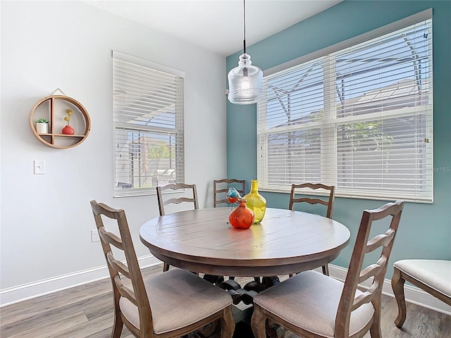 dining space featuring baseboards and light wood finished floors