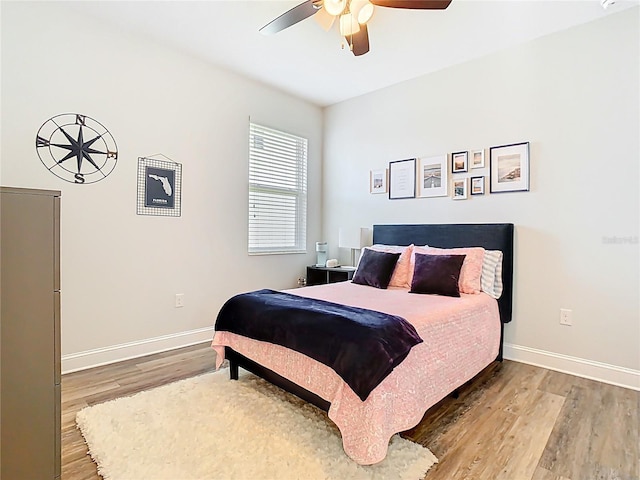 bedroom with ceiling fan, baseboards, and wood finished floors