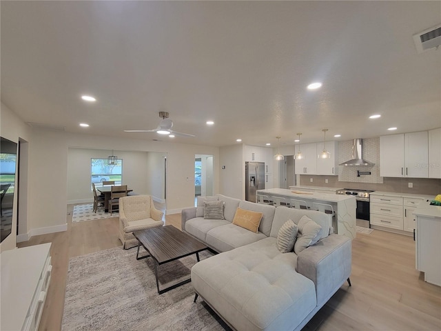 living room with visible vents, a ceiling fan, recessed lighting, light wood finished floors, and baseboards