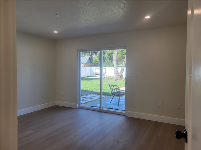 empty room featuring recessed lighting, baseboards, a textured ceiling, and dark wood-style floors