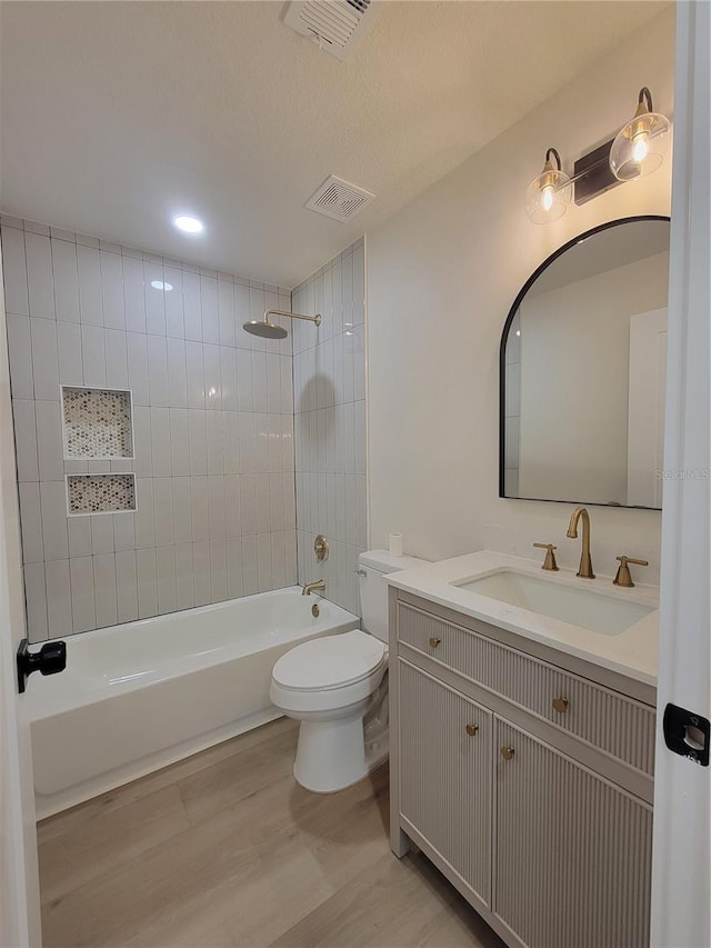 full bathroom with visible vents, toilet, shower / washtub combination, and wood finished floors