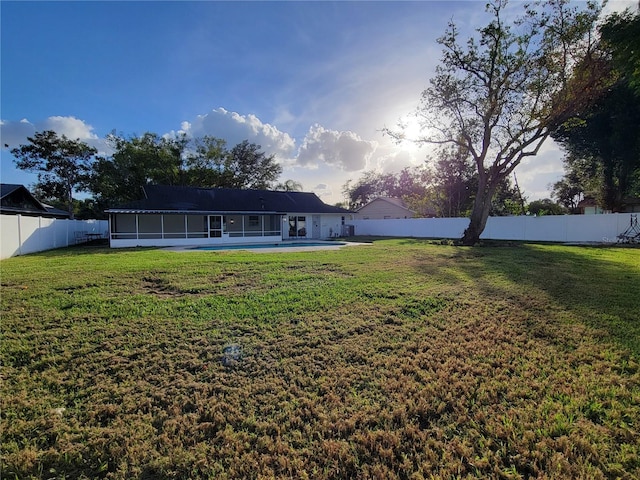 exterior space featuring a fenced backyard and a sunroom