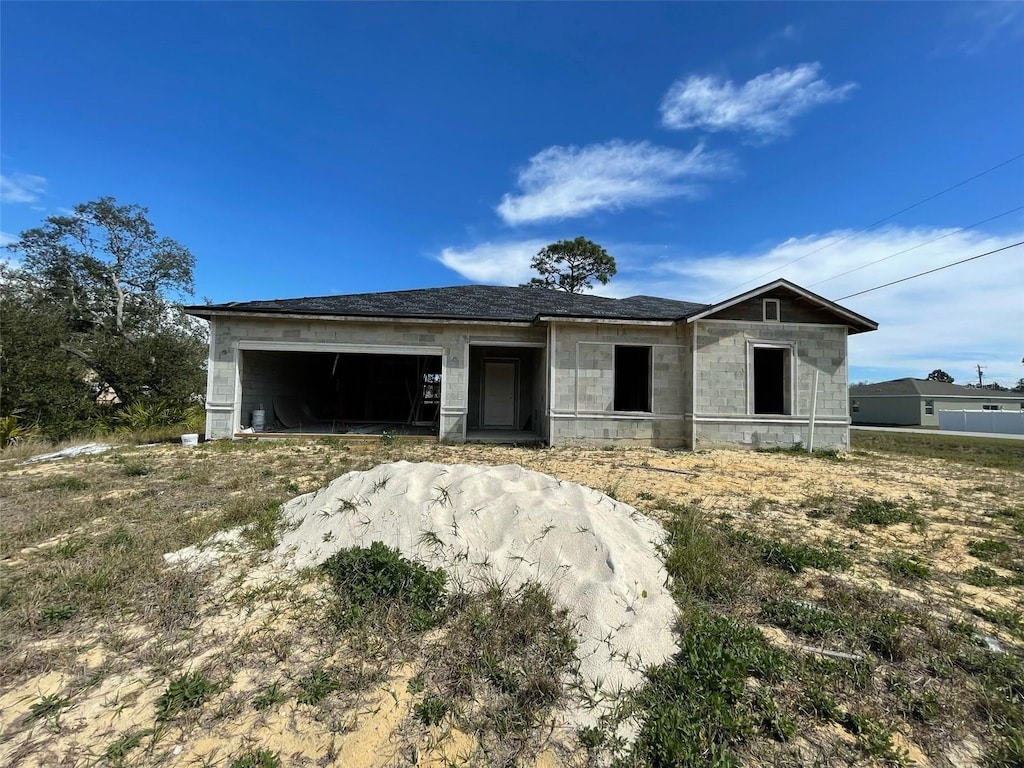 property under construction featuring concrete block siding and an attached garage