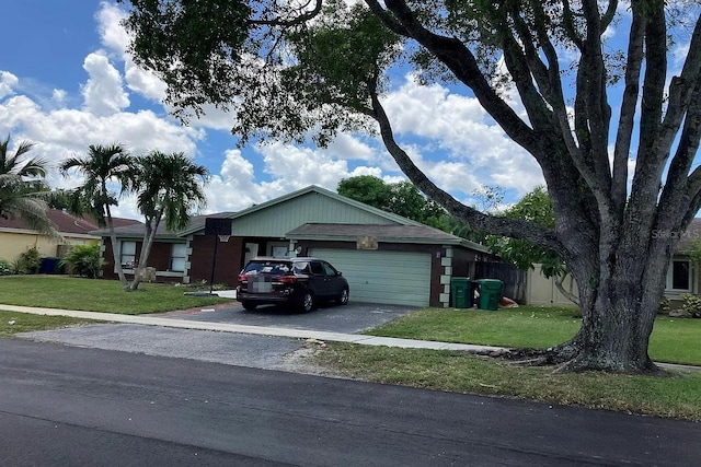 ranch-style home featuring driveway, an attached garage, and a front lawn