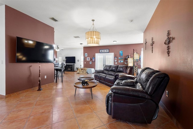 living area featuring light tile patterned floors, visible vents, french doors, and ceiling fan