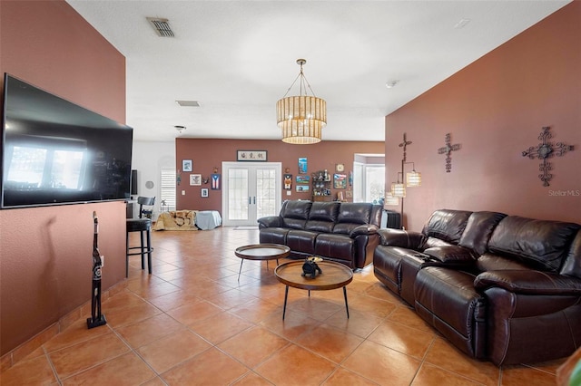 living room featuring light tile patterned floors, visible vents, and french doors