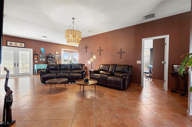 living room with light tile patterned flooring, visible vents, and french doors