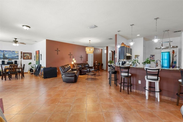 living room with light tile patterned floors, visible vents, and a ceiling fan