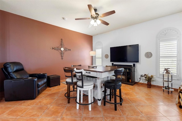 dining area with light tile patterned floors, baseboards, and ceiling fan