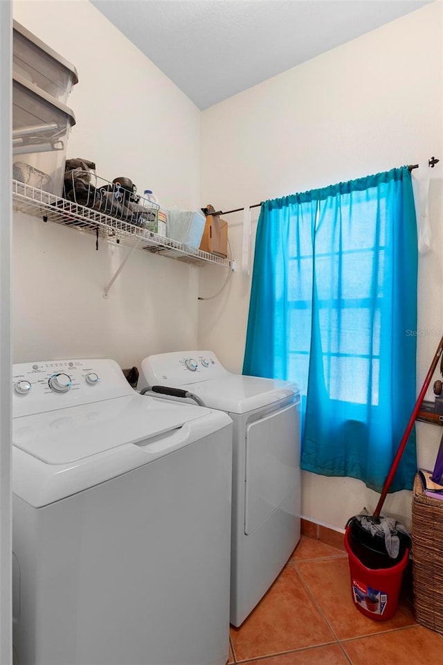 washroom featuring laundry area, light tile patterned floors, and separate washer and dryer