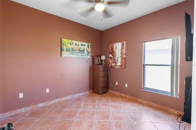 spare room with light tile patterned floors, baseboards, and ceiling fan