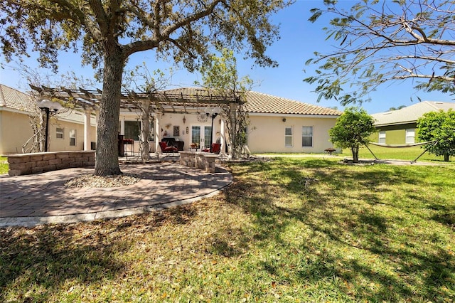 back of house featuring a tiled roof, a yard, a patio, and stucco siding