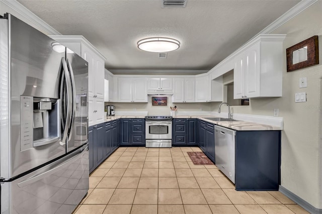 kitchen featuring visible vents, blue cabinetry, stainless steel appliances, white cabinetry, and a sink