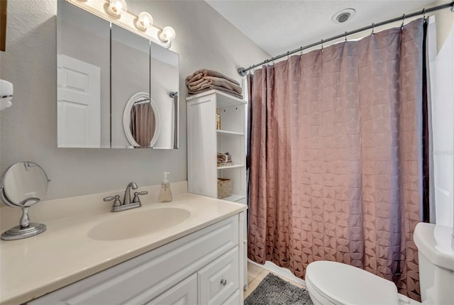 full bathroom featuring tile patterned floors, shower / bath combo with shower curtain, toilet, and vanity