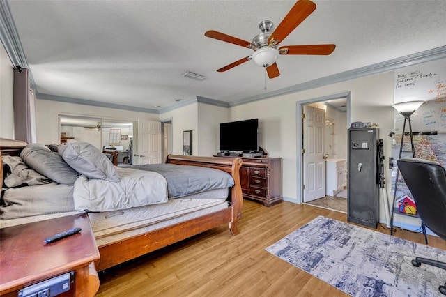 bedroom with visible vents, light wood-style floors, ornamental molding, and a textured ceiling