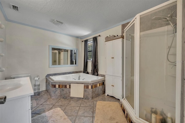 full bathroom featuring visible vents, a shower stall, vanity, a garden tub, and a textured ceiling