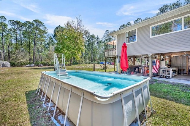 outdoor pool featuring a lawn and a deck