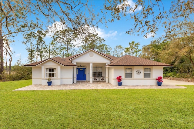 view of front of property with stucco siding, a shingled roof, and a front lawn