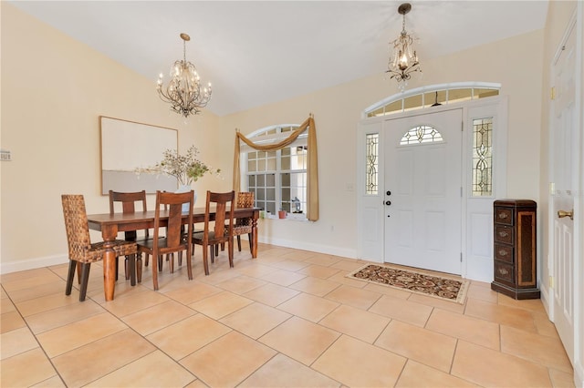 entryway with a chandelier, light tile patterned floors, and baseboards