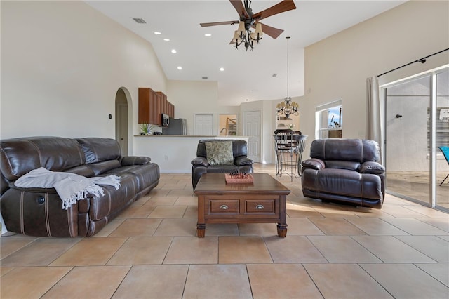 living area featuring arched walkways, visible vents, ceiling fan, and light tile patterned floors