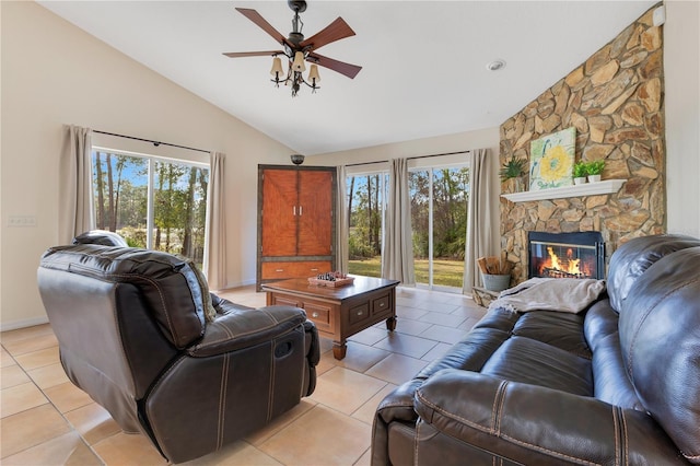 living room with baseboards, lofted ceiling, light tile patterned flooring, a fireplace, and ceiling fan