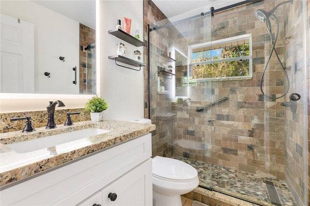 full bathroom featuring a tile shower, toilet, and vanity