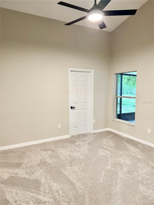 unfurnished room with baseboards, carpet, and a ceiling fan