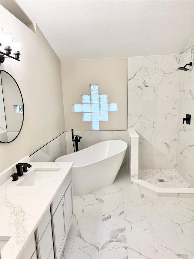 full bath featuring a marble finish shower, a freestanding tub, a sink, a textured ceiling, and marble finish floor