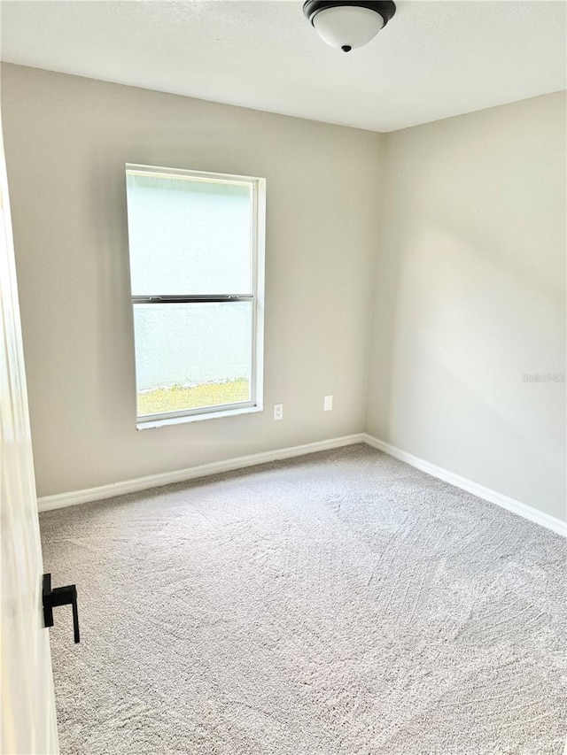 carpeted spare room with baseboards