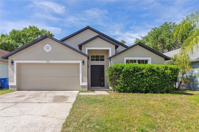 ranch-style house with concrete driveway, a garage, a front yard, and stucco siding