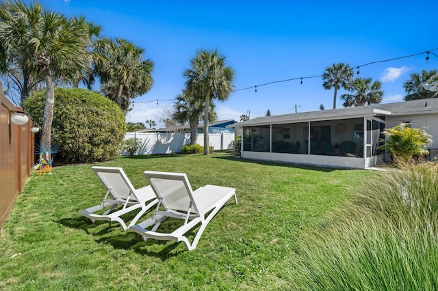 view of yard with a fenced backyard and a sunroom