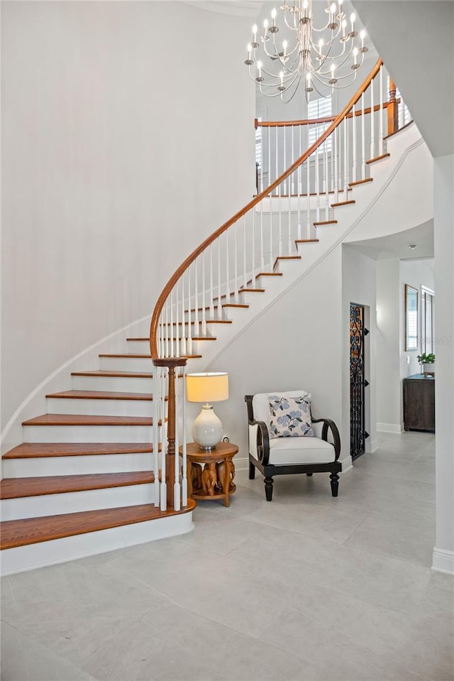 stairway with baseboards and a towering ceiling